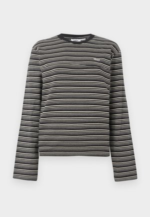 Long-sleeve crewneck top featuring black and cream horizontal stripes, with a small white logo on the chest. Made of soft fabric.