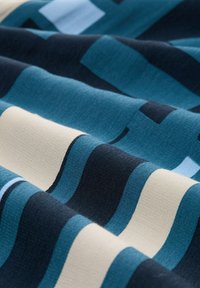 Textile featuring alternating stripes in teal, navy blue, and cream, with a soft, textured fabric creating a wavy, layered appearance.