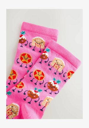 Różowe skarpetki z powtarzającym się wzorem rysunkowych ciasteczek i świątecznych smakołyków, z kolorowymi akcentami i miękkim, teksturowanym materiałem.