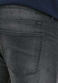 Gray denim jeans with a slim fit, featuring a back pocket, subtle stitching details, and a "Blend" label near the waistband.