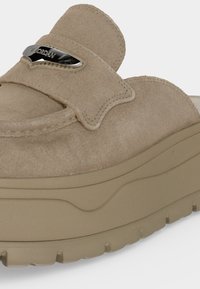 Μπεζ σουέντ παπούτσι slip-on με παχιά λαστιχένια σόλα και ασημί διακόσμηση λογότυπου "Air Jordan" στο πάνω λουρί.