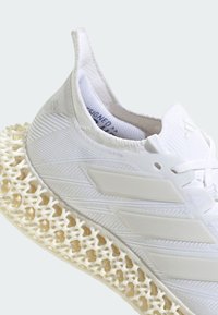 White athletic shoe with a woven upper and distinctive lattice midsole. Features textured accents and three parallel stripes on the side.