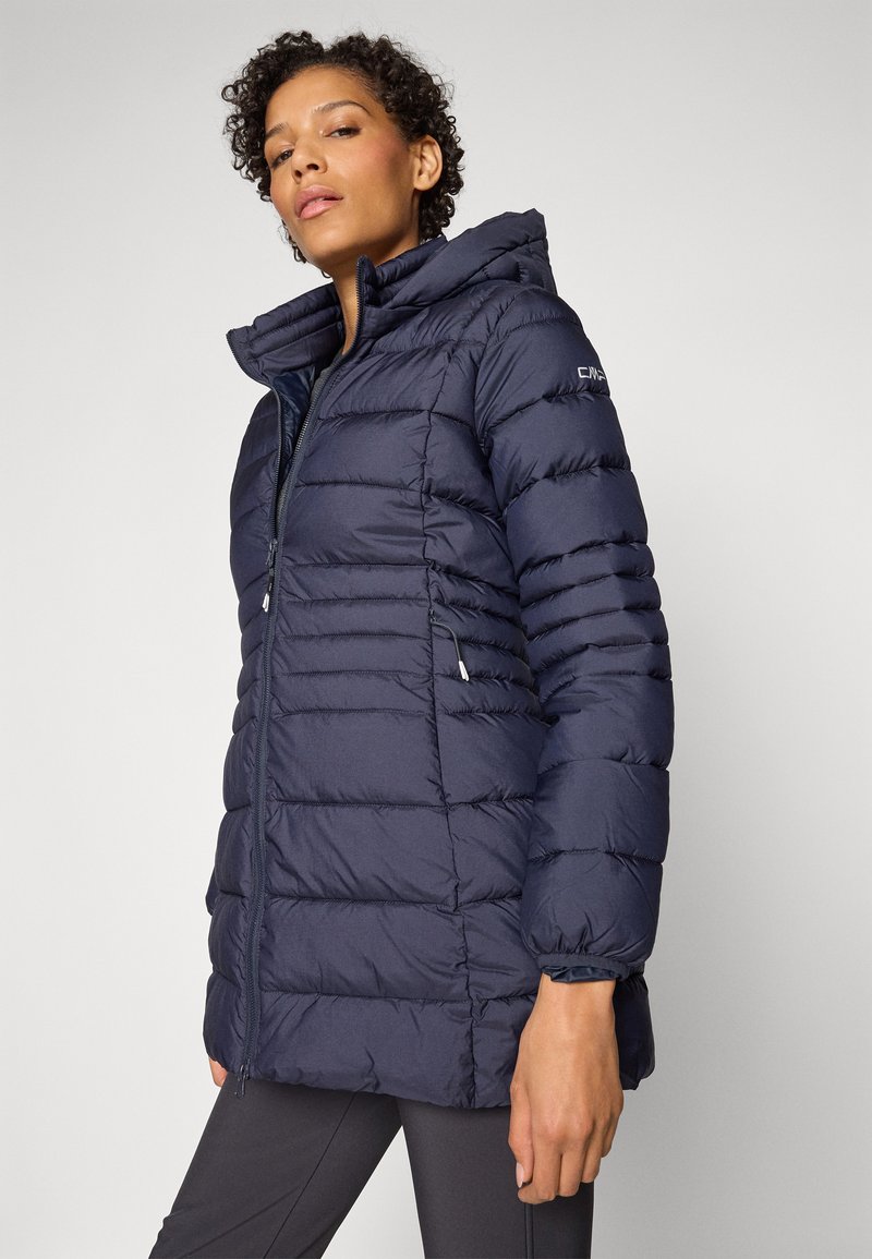 Giacca a vento blu navy con cappuccio, caratterizzata da un design trapuntato, zip frontale e polsini elasticizzati. Materiale leggero con tasche laterali.