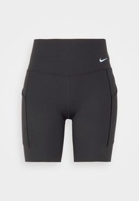 Short de sport noir taille haute avec poches latérales et petit logo blanc Nike sur la hanche gauche, sur fond uni.