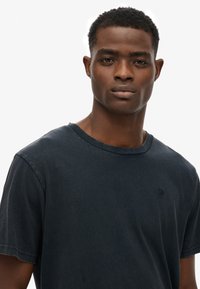 Blå bomulds t-shirt med rund halsudskæring, korte ærmer og et diskret logo på brystet. Blødt, afslappet stof med en løs pasform.