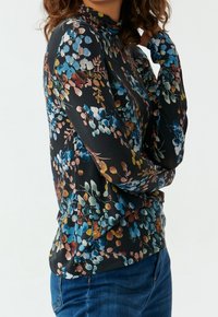 Langärmliges Oberteil aus schwarzem Stoff mit einem floralen Muster in Blau, Pink und Gelb, mit einem hohen Kragen und einer taillierten Passform.