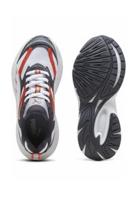 Bílé atletické boty s šedými a oranžovými detaily, které mají síťovinový svršek, polstrovaný límec a texturovanou černou gumovou podrážku pro lepší přilnavost.