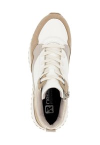 Baskets blanches et beiges avec une tige en cuir lisse et en daim, bout arrondi, design à lacets et semelle en caoutchouc texturée avec des rainures.