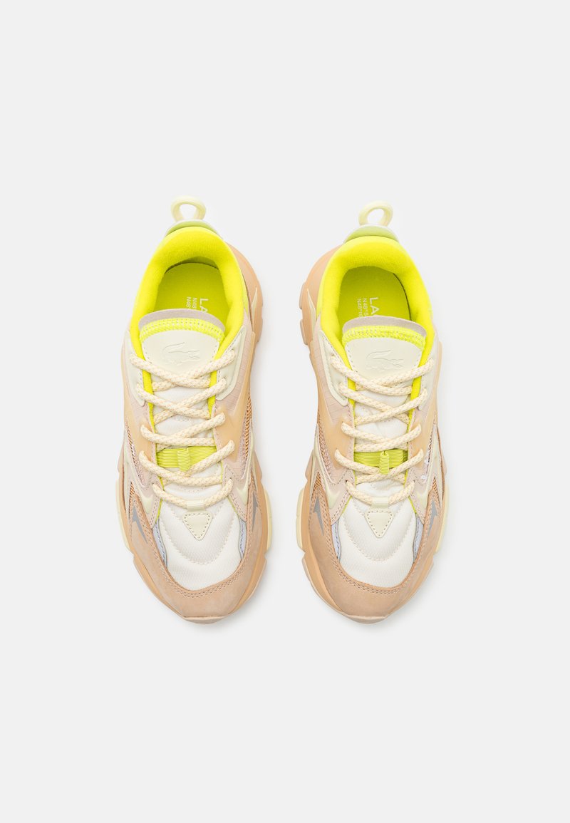 Sneakers z beżową i białą siateczką, limonkowymi akcentami oraz teksturowaną gumową podeszwą. Odbijające światło detale po bokach.