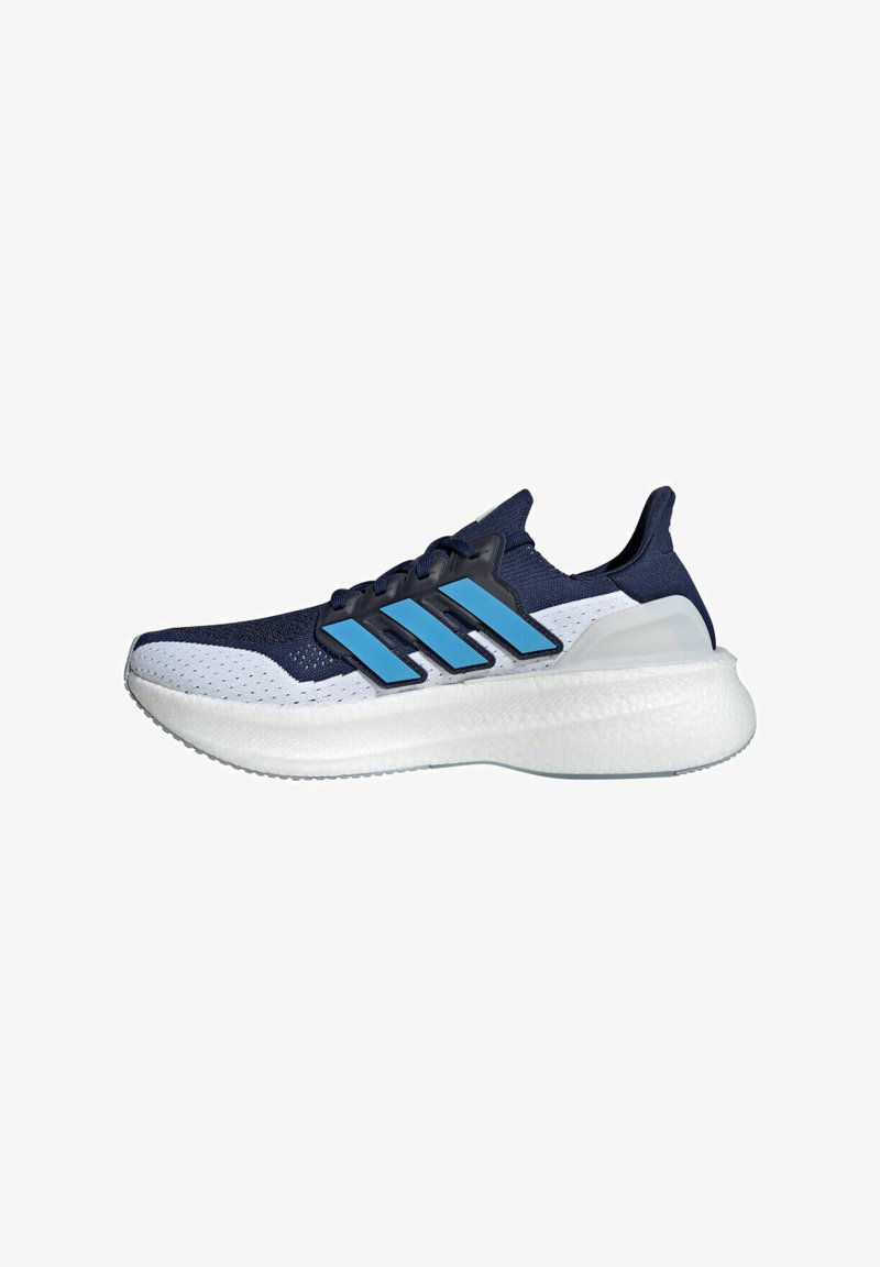 Zapatilla deportiva en marino y blanco con parte superior de malla, acentos azules y suela de goma gruesa. Presenta tres franjas azules y un talón acolchado.