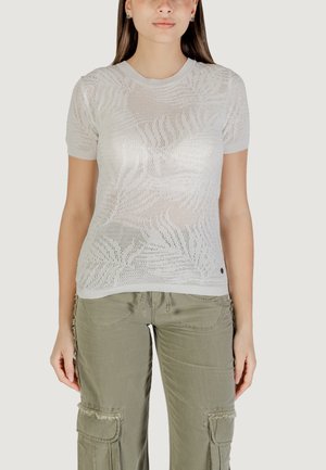 Top corto a maniche corte di colore bianco, realizzato in maglia con un motivo aperto e testurizzato; scollatura a girocollo; abbinato a pantaloni cargo verde oliva con tasche e dettagli sfrangiati.