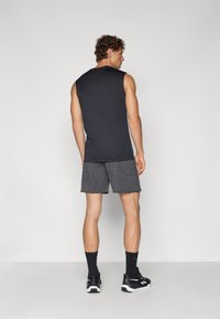 Camiseta preta sem mangas, calções cinza mescla, meias pretas e sapatos atletismo. O design é simples, com uma silhueta ajustada e tecido liso.