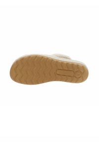 Suela de zapato slip-on beige con una superficie de goma texturizada que presenta un patrón ondulado para mayor tracción y durabilidad. Se observa un branding mínimo.