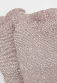 Lyserøde glitrende knæhøje sokker med et tekstureret ribbet design og en flæset kant foroven, der har en subtil glans i hele stoffet.