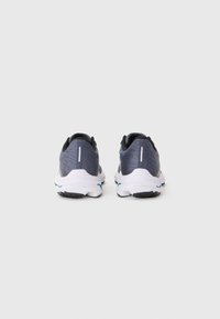 Baskets de sport grises avec un dessus texturé, semelle blanche et accents bleus. Comprend un talon rembourré et des éléments réfléchissants pour la visibilité.