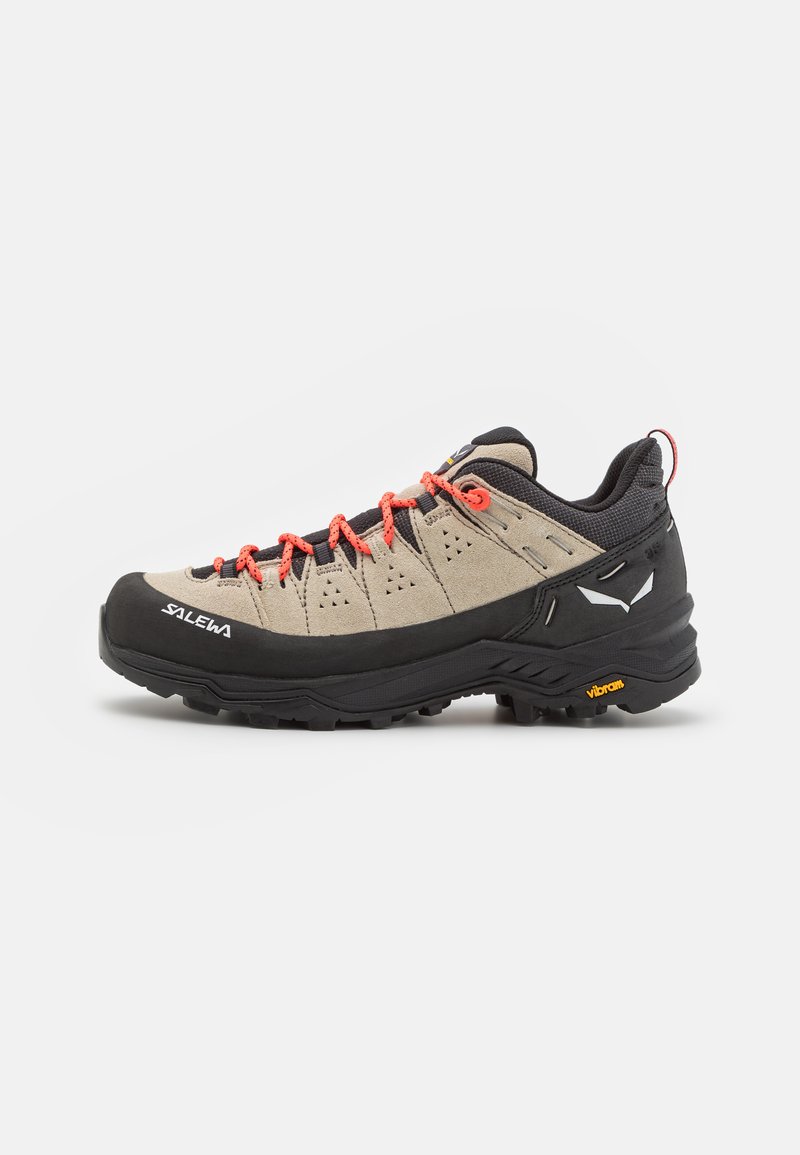 Lightweight hiking shoe with a tan suede upper, black rubber sole, orange laces, and gray accents. Features Vibram outsole for traction.