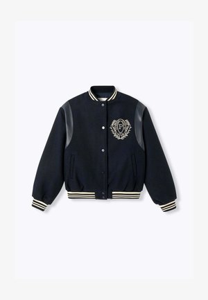 Veste universitaire noire avec des patchs en cuir sur les épaules, des poignets et un ourlet rayés, des boutons pression et un blason brodé sur la poitrine gauche.