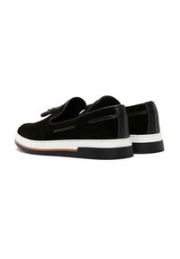 Black suede shoes with a smooth finish, white rubber sole, and angular design. Features decorative cut-outs along the sides.
