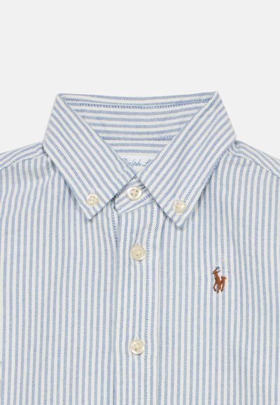 Πουκάμισο με γιακά, κουμπιά, κάθετες μπλε και λευκές ρίγες, λευκά κουμπιά και μικρό κεντητό λογότυπο καφέ αλόγου στο στήθος.