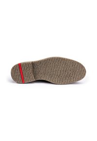 Semelle de chaussure avec une surface en caoutchouc texturé, présentant une bande d'accent rouge et une forme large et arrondie. Le design permet une meilleure adhérence.