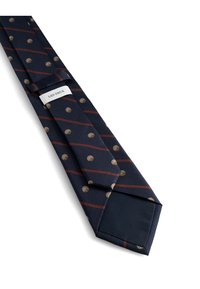 Granatowy krawat z diagonalnymi czerwonymi paskami i złotymi kropkami. Uszyty z gładkiego materiału, ma spiczasty koniec oraz metkę na wąskim końcu.