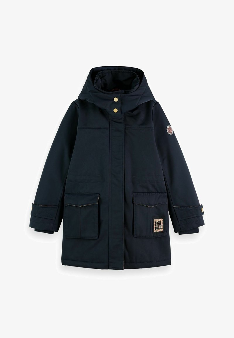 Manteau d'hiver bleu marine à capuche avec poches avant à rabat, boutons-pression dorés, poignets ajustables et un petit écusson sur la poche inférieure droite.