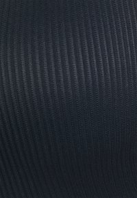 Σκούρος ναυτικός ριγέ ύφασμα με ομοιόμορφα κατανεμημένες κάθετες γραμμές, δημιουργώντας μια υφή με λεία επιφάνεια.