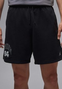 Zwarte katoenen shorts met een elastische tailleband, trekkoord, zijzakken en bedrukt met "JORDAN" en "84" op het linkerpantbeen.