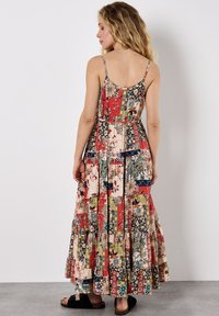 Maxikleid mit dünnen Trägern, ausgestattet mit einem Patchwork-Blumenmuster in Rot, Creme und Blau sowie einem geschichteten Rüschensaum. Strukturierter Stoff.