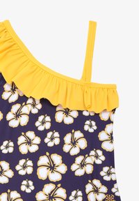 Maillot de bain asymétrique en bleu marine avec un motif floral d'hibiscus blanc et jaune. Présente un détail de volants jaune le long de l'encolure.
