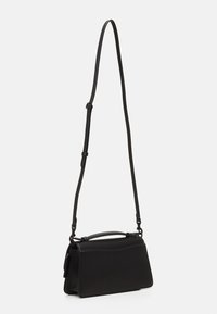 Bolso de cuero negro con forma estructurada, un asa superior, correa ajustable y detalles de costura en contraste. Textura suave, diseño minimalista.