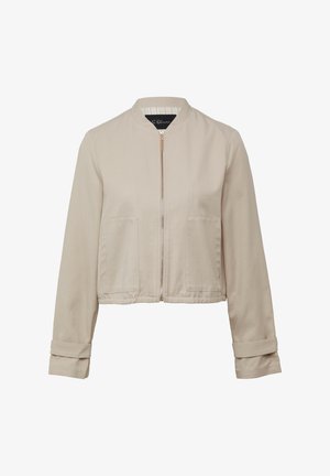 Veste courte beige en mélange de coton, avec un col montant, une fermeture éclair, deux poches avant et des détails de manches retroussées.