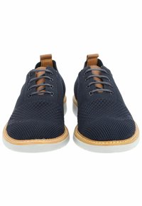 Scarpe a rete blu navy con suole bianche, dotate di sei fori per i lacci, dettagli marroni sulla linguetta e una tomaia texturizzata.