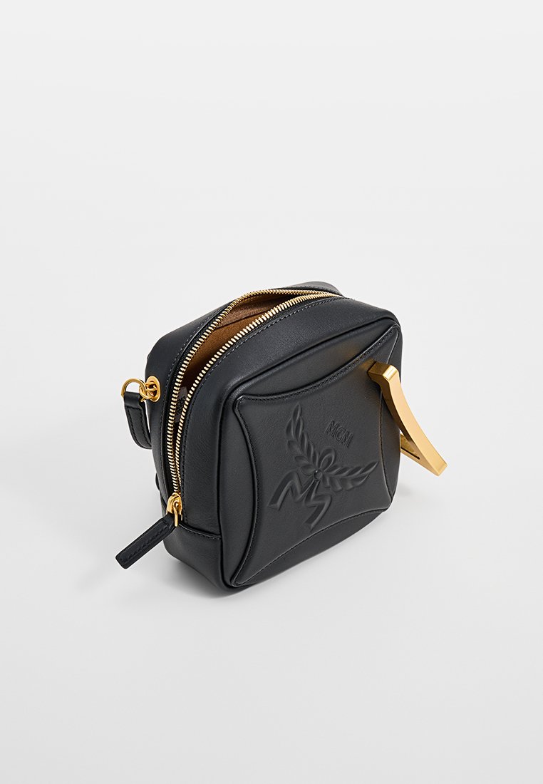 Schwarze Leder-Kosmetiktasche mit goldenen Beschlägen, geprägtem Logo, doppeltem Reißverschluss und strukturiertem Design. Glatte Textur mit minimalen Akzenten.