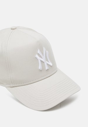 Helle beige Baseballmütze mit gebogenem Schirm. Auf der Vorderseite befindet sich ein gesticktes, weißes "NY"-Logo. Hergestellt aus einem strukturierten Stoff.