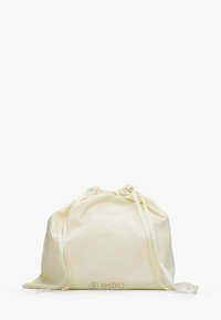 Kremowy worek ze ściągaczem wykonany z miękkiego materiału, z marszczonym górnym brzegiem i nadrukowanym logo z przodu. Gładka tekstura, prosty design.