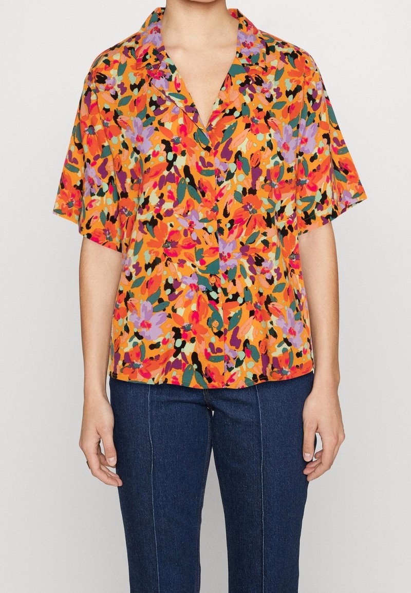 Kurzarmhemd mit einem lebhaften Blumenmuster in Orange-, Lila- und Grüntönen, mit lockerem Schnitt und Knopfleiste.