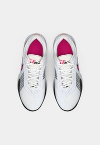Hvide atletiske sneakers med pink detaljer. Har et ternet mønster på siden, perforeret tekstur på tåen og sorte såler.