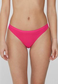 Bas de bikini rose fabriqué à partir d'un tissu lisse et extensible. Présente un design taille basse et une ceinture contrastante. Construction simple et sans coutures.