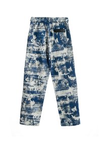 Pantalones de patrón azul y blanco con cintura elástica y dos bolsillos traseros. La tela tiene un diseño texturizado, similar a la pintura.