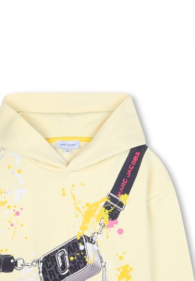 Gelber Kapuzenpullover mit abstrakten, bunten Spritzdesigns, einem grafischen Taschenprint und einem schwarzen Tragegurt mit dem Text "MARC JACOBS".