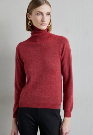 Roter Rollkragenpullover aus einem weichen, strukturierten Material mit langen Ärmeln sowie gerippten Bündchen und Saum, kombiniert mit schwarzen Hosen.