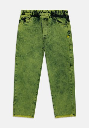 Grüne Jeans mit Acid-Waschung, elastischem Bund, Fronttaschen und ausgefransten Säumen, mit einem kleinen gelben Etikett auf der rechten Seite.
