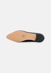 Scarpa in pelle intrecciata nera con punta affusolata e suola piatta. La soletta è beige, con dettagli del marchio e taglia 37. Texture liscia nel complesso.