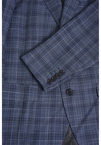 Mörkblå rutig blazer med en texturerad tyg, slagkrage, tre-knappars manschetter och en enkel knappknäppning framtill.