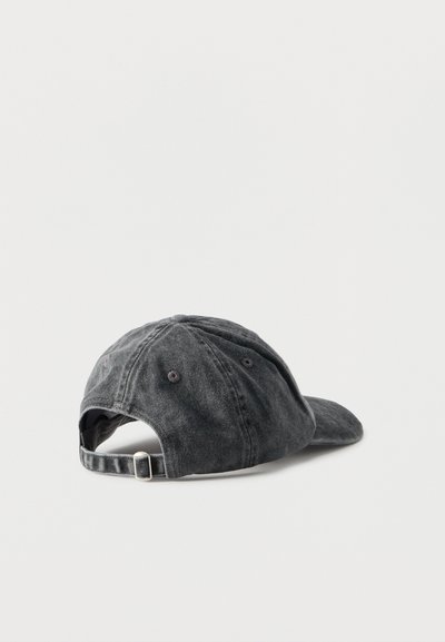 Tamsiai pilka medvilninė beisbolinė kepurė su reguliuojama juostele ir metaline sagtimi, rodoma iš nugaros ant balto fono.
