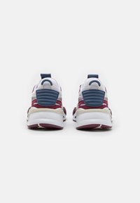 Czerwono-białe tekstylne sneakersy z niebieskimi akcentami, wyściełanym kołnierzem, fakturowanym obcasem i białą podeszwą. Posiadają pętlę do ściągania z tyłu.