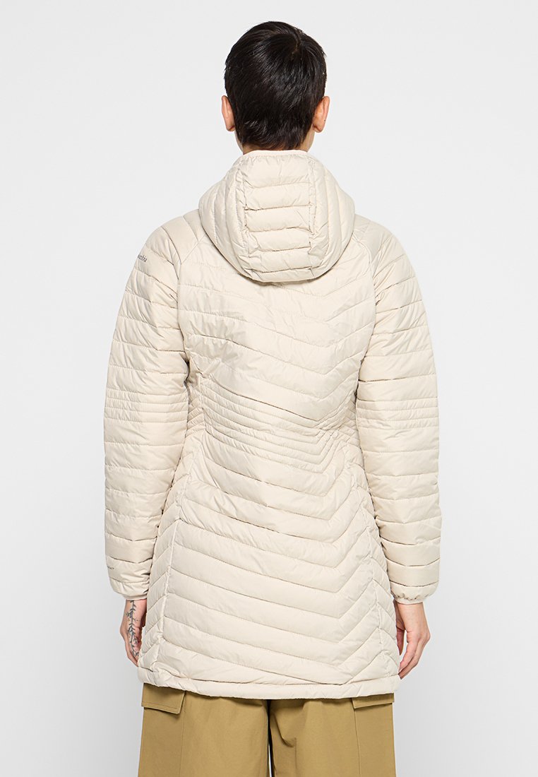 Lichtbeige pufferjack met een tekstuur in een chevronpatroon. Voorzien van een afneembare capuchon en lange mouwen, ontworpen voor warmte en comfort.