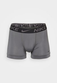 Boxeri pentru bărbați gri, cu un tiv elastic negru pe care se află logo-ul Nike. Design neted, ajustat, cu o croială de lungime medie și cusături minime.