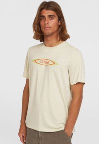 Helle beige Kurzarm-T-Shirt aus weichem Stoff, mit einem zentralen O'Neill-Logo in Orange und Grün in ovalem Design.